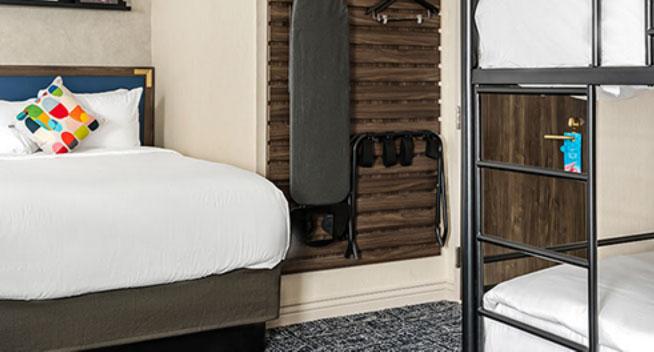 King Bed with Bunk for 2 King Bed showing ironing board hanging on wall with lsuitcase rack and clothes hanger