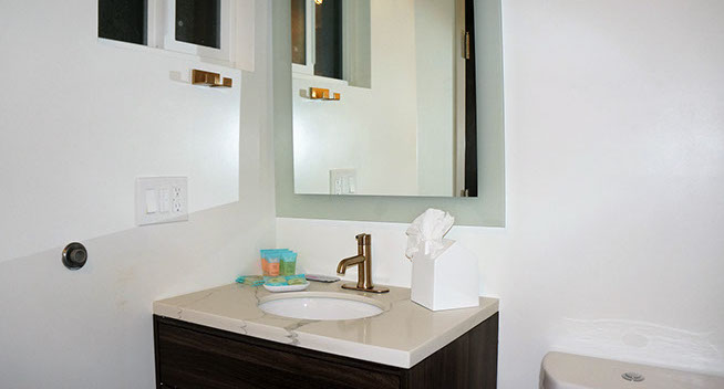 Full Size Bed Guest Room Photo showing your restroom facility. Single sink with brass fixtures, and medicine cabinet with mirror.