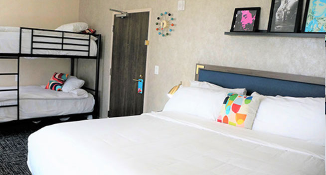 King Bed with Bunk bed This room features a large king bed and a bunk bed for 2.  Colorful retro moderrn wall clock and photos above bed.