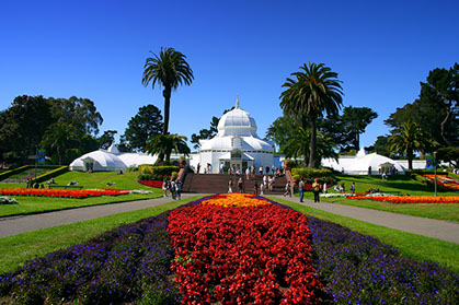 Golden Gate Park - Conservatory of Flowers view of Conservatory of Flowers in the Golden Gate Park. Beautiful red and orange flowers mixed with purple line the grass ways.